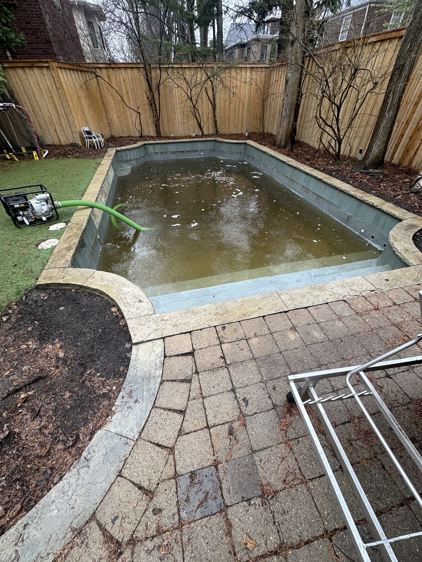 Rectangular pool before cleaning — brown murky water